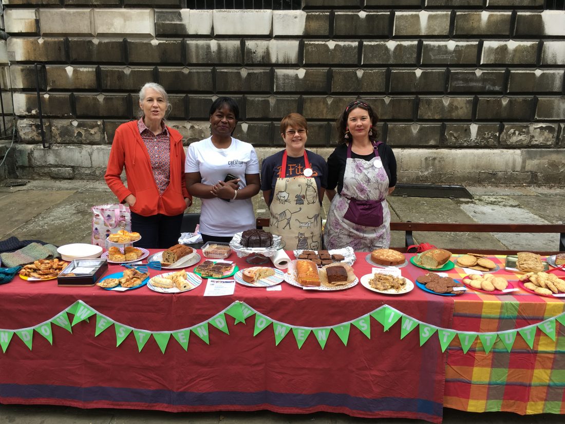 Photo of stall at St Giles Fayre - a table of homemade cake with four women ready to serve